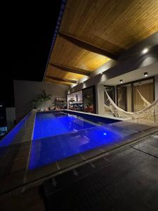 a swimming pool with blue lighting in a house at Cobertura Milagres do Chef in São Miguel dos Milagres