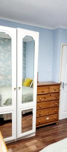 a bedroom with a dresser and a mirror at Holiday Apartment in Abbey Wood