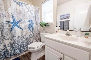 uma casa de banho com uma cortina de chuveiro, um WC e um lavatório. em Oceanfront 4BR, Peaceful, Cozy, Kids/Pet Friendly! em Freeport