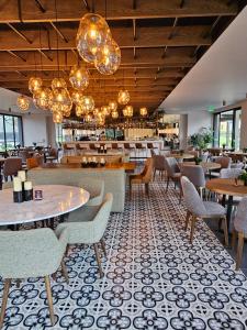 a dining room with tables and chairs and chandeliers at Hotel Estelar El Cable in Manizales