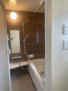 a bathroom with a bath tub and a sink at ゆうゆう八街新築4LDK free wifi in Yachimata