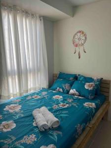 馬尼拉的住宿－Comfyplace5 in Urban Deca Homes Manila，一间卧室配有蓝色的床和毛巾