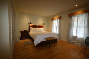 1 dormitorio con 1 cama grande y 2 ventanas en GÎTE SUR L'ARC EN CIEL, en Saint Adrien