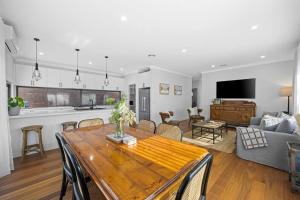 cocina y sala de estar con mesa de madera y sillas en Duc De Malakoff en Ballarat