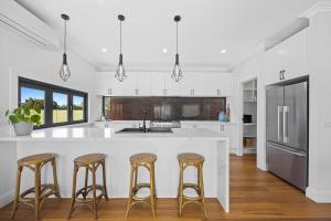 a kitchen with a large white island with bar stools at Duc De Malakoff in Ballarat