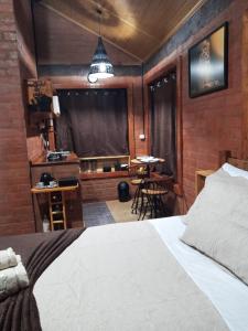 1 dormitorio con 1 cama, cocina y mesa en Chalet di Alta Montagna en Santo Antônio do Pinhal