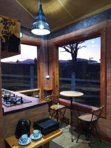 uma cozinha com um balcão, uma mesa e uma janela em Chalet di Alta Montagna em Santo Antônio do Pinhal