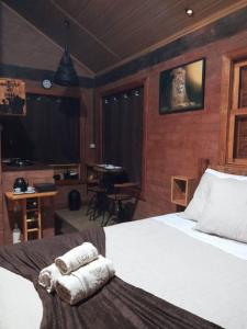 a bedroom with a bed with towels on it at Chalet di Alta Montagna in Santo Antônio do Pinhal