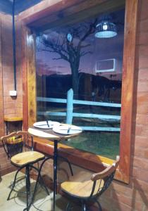 een kamer met een tafel en stoelen en een schilderij van een boom bij Chalet di Alta Montagna in Santo Antônio do Pinhal
