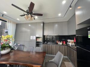 cocina con mesa de madera y ventilador de techo en Nancy Grand Partea Villa, en Xã Thang Tam