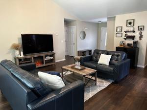 a living room with leather furniture and a flat screen tv at The Coffee Pitstop! in Saint Robert