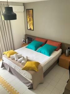 a bedroom with a large bed with colorful pillows at Good Mood Studio - Manganao Hôtel in Saint-François