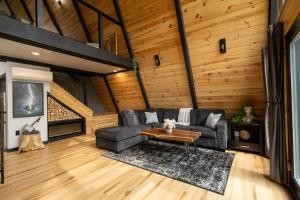 a living room with a couch and a table at Valhalla Cabins AFrames with hot tubs & sauna in Cosby +85 photos