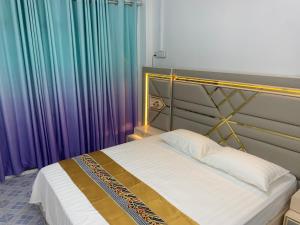 Bett in einem Zimmer mit Regenbogen-Vorhängen in der Unterkunft Ontrack Travel in Male City