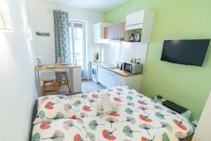 a small room with a bed and a kitchen at Studio coquet rénové - Villeurbanne in Villeurbanne