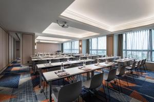 a large room with tables and chairs and windows at Mercure Guangzhou Baiyun International Airport - Airport Free Shuttle Bus in Huadu