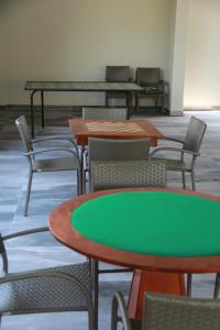 a room with tables and chairs and green tables and chairs at HOTELParque Veredas flat 327 VISTA PARA PISCINA ASCESSO AO RIO AO LADO DO HOT PARK FABULOSO in Rio Quente
