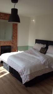 a bedroom with a large bed and a fireplace at The Railway Inn Westerfield in Ipswich