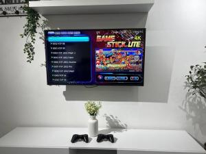 a tv on a wall with a video game on it at Modern HS Sweet Homestay Kuantan in Kuantan