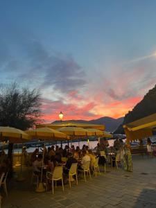 un grupo de personas sentadas en sillas bajo sombrillas en una playa en Lisetta Rooms, en Vernazza