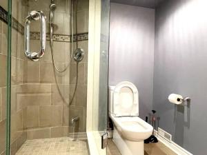 La salle de bains est pourvue de toilettes et d'une douche en verre. dans l'établissement Ella's Cozy Retreat at Richmond Hill, à Colline De Richmond