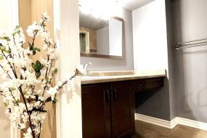 a bathroom with a sink and a vase of flowers at Ella's Cozy Retreat at Richmond Hill in Richmond Hill