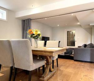 a dining room table with a vase of flowers on it at Ella's Cozy Retreat at Richmond Hill in Richmond Hill