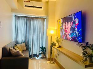 a living room with a large flat screen tv on a wall at Shore 3 Tower 1 MOA Pasay F Suite Staycation in Manila