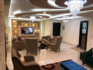 ein Wohnzimmer mit Sofas und einem Flachbild-TV in der Unterkunft فندق وشقق المهندسين جامعه الدول العربية in Kairo