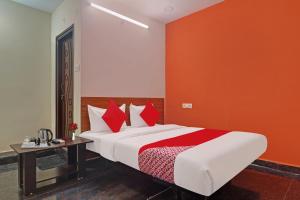 sypialnia z dużym łóżkiem z czerwoną ścianą w obiekcie Super OYO Flagship Sai Mansion w mieście Hajdarabad