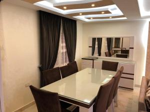 a dining room with a white table and chairs at فندق وشقق المهندسين جامعه الدول العربية in Cairo