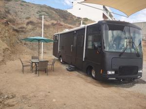 une camionnette noire garée à côté d'une table avec un parasol dans l'établissement Capitan Boutique Resort, à Puerto Nuevo