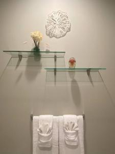 een badkamer met 3 handdoeken en een glazen plank bij Sanctuary at edge of forest in Ladysmith