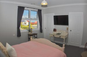 1 dormitorio con cama, escritorio y ventana en Number 10 -Queen Room with b/fast, en Stanley