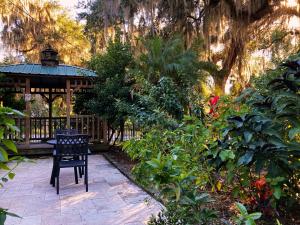 a wooden gazebo with a chair in a garden at Retreat at Crystal Manatee in Crystal River