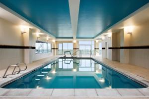 a swimming pool in a building with a blue ceiling at Courtyard Kansas City at Briarcliff in Kansas City