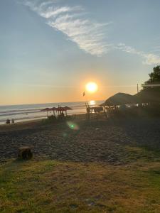 a sunset on the beach with the sun setting at Tropical Vibes Beach House in San Rafael