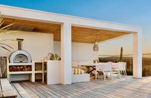 a kitchen and dining area of a house with a deck at Sanctuary Spaces - Sundowner in Byron Bay