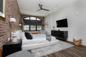 a living room with a white couch and a brick wall at Lap Of Luxury Penthouse W Rooftop, Secure Parking in Atlanta