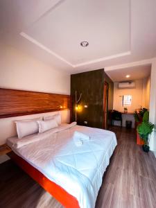 a bedroom with a large bed with a wooden headboard at M-Resort Siargao in General Luna
