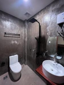 a bathroom with a white toilet and a sink at M-Resort Siargao in General Luna