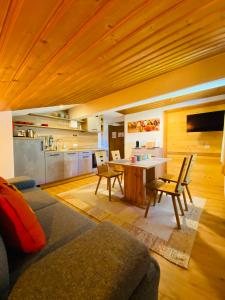 a living room with a table and a kitchen at Apart Berghof Steinbock in Sankt Leonhard im Pitztal