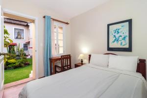 Un dormitorio con una gran cama blanca y una ventana en Hotel La Cartuja, en Quito