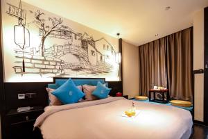 昆明Gongxili-Xijian Hotel - Kunming Dongfeng East Road Dashuying Metro Station的卧室里有一张大床，配有蓝色枕头