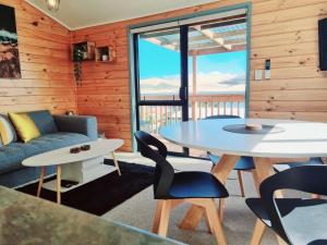 a living room with a table and chairs and a couch at Opononi Bliss in Opononi