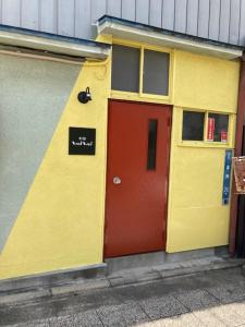 富岡市にあるお宿わいわいの赤のドアの黄色・赤の建物