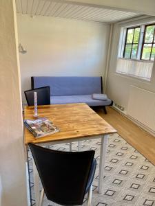 a room with a table and a blue couch at beach room in Snogebæk