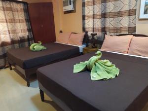 dos camas con animales de peluche en una habitación en St. John Island View Pensionne, en El Nido