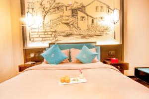 昆明Gongxili-Xijian Hotel - Kunming Dongfeng East Road Dashuying Metro Station的一间酒店房间，房间里有一张床，床上放着一盘食物 更多28张照片