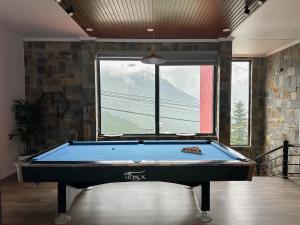 a pool table in a room with a large window at Bách Xanh House in Tam Ðảo +35 photos